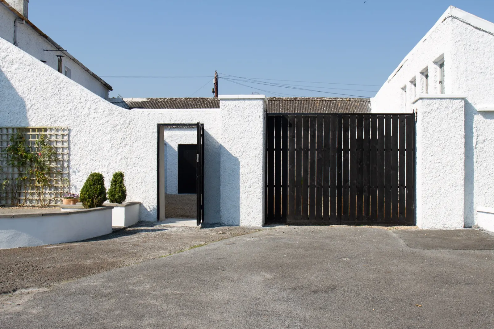 Enclosed rear courtyard with timber gates and off-street parking